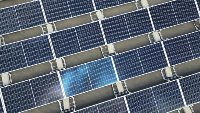 Aerial view of a large array of solar panels on a rooftop, utilizing renewable energy.