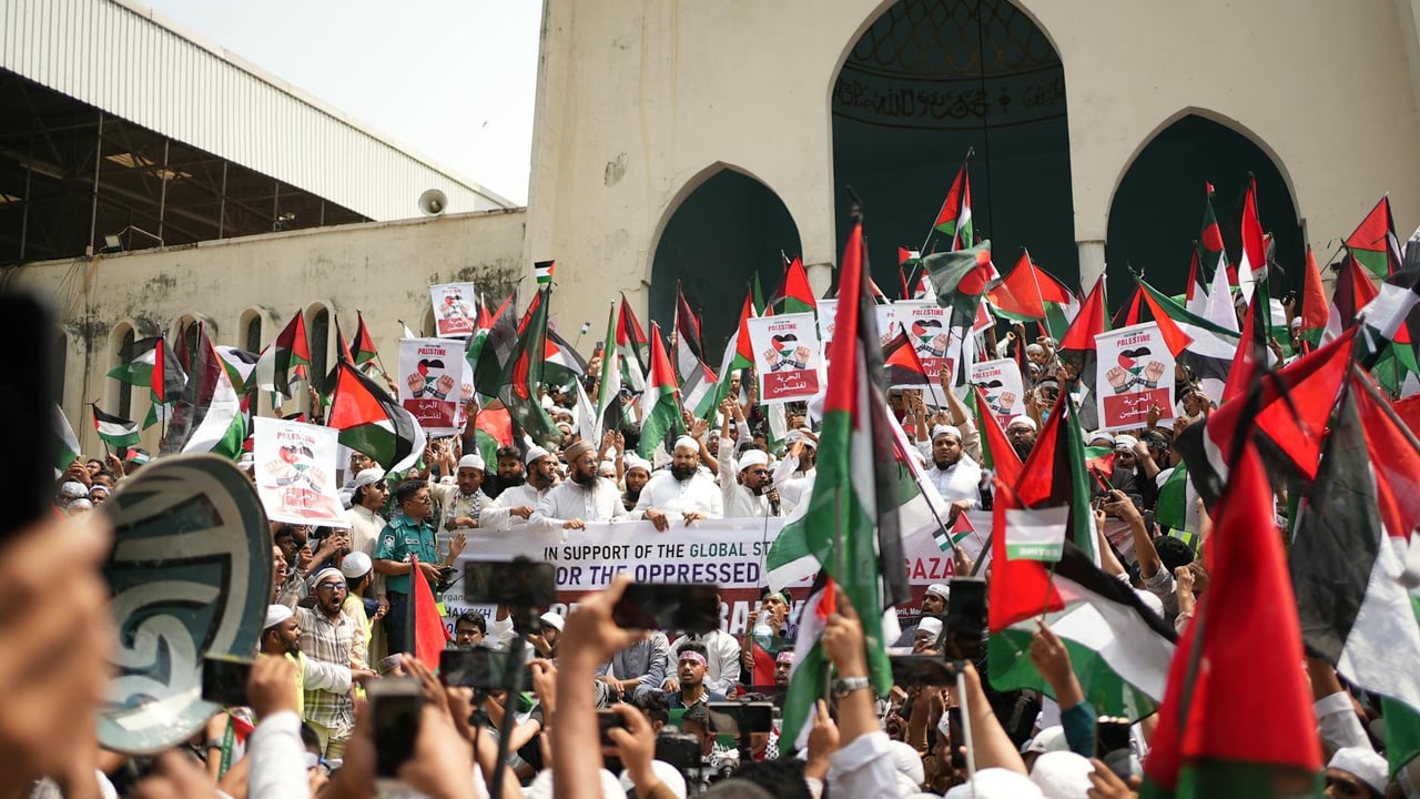 Large Pro-Palestinian demonstration in Dhaka with flags and banners supporting freedom and solidarity.