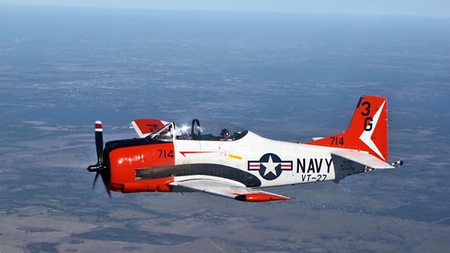 A vintage T-28 Trojan aircraft in flight over Florida, showcasing classic US Navy aviation design.