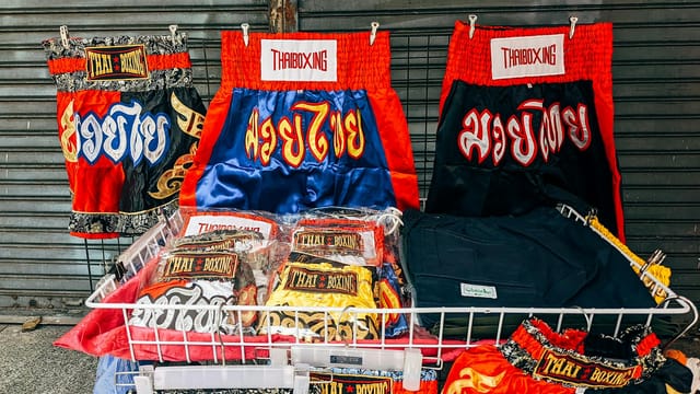 Vibrant Thai boxing shorts on display in Bangkok market, showcasing local culture.