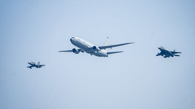 Three aircraft flying in a clear blue sky in formation, showcasing military aviation.