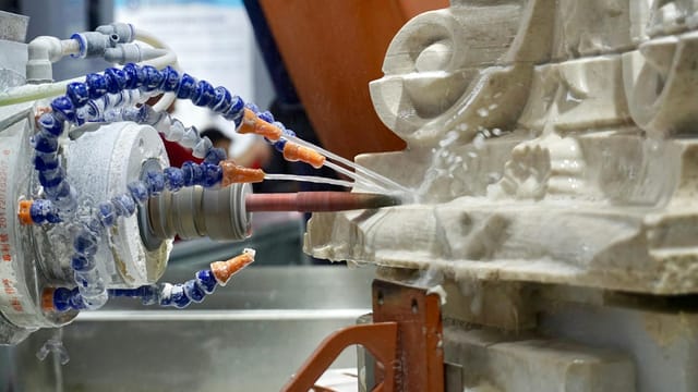 Close-up of a robotic machine sculpting stone with high precision in an industrial setting.