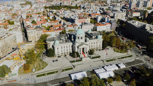 A stunning aerial view of the National Assembly building in Belgrade, Serbia, under clear skies.