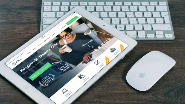 A tablet with a financial website open, alongside a white keyboard and mouse. Ideal for tech-theme stock images.