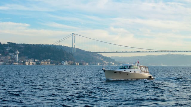 A serene boat ride on the Bosphorus with Istanbul's iconic bridge in the background.