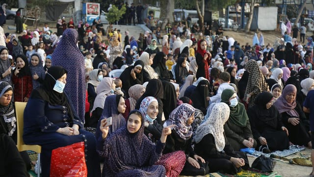 Vibrant crowd celebrating Eid prayers outdoors in Gaza City, showcasing Palestinian traditions.