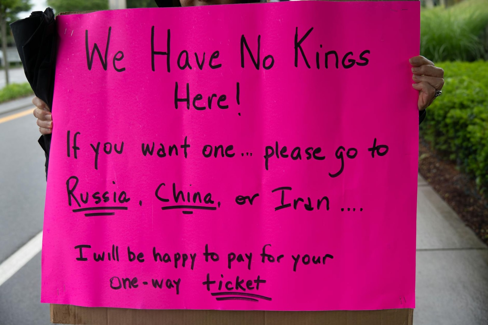 A vibrant protest sign in South Kingstown, Rhode Island, advocating against monarchies with political messaging.