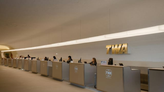 Reception desks at TWA Hotel, showcasing retro-modern design in JFK Airport, New York.