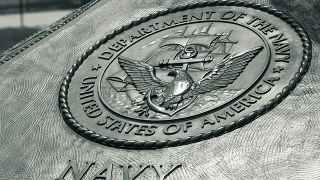 Detailed view of the United States Navy emblem on a monument in Washington D.C., showcasing naval heritage.