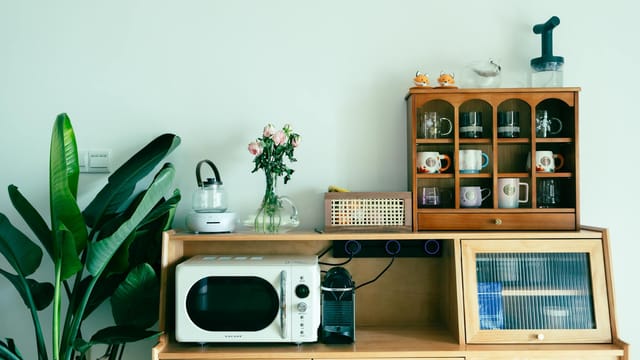 Charming kitchen setup featuring vintage appliances and decor on a wooden dresser.