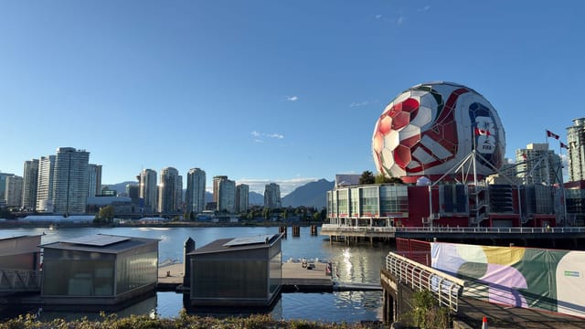 View of Vancouver skyline featuring Science World and a giant soccer ball at sunset.