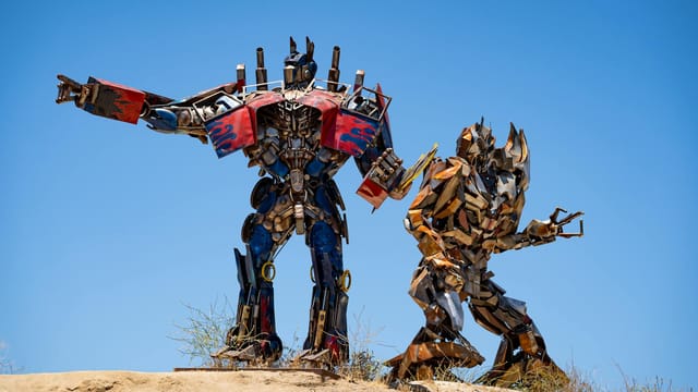 Metal sculptures resembling transformers under a bright blue sky in Aguanga, CA.