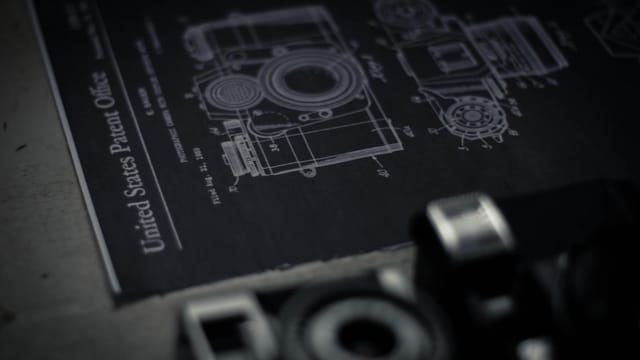 Detailed blueprint of a camera with an official patent from the United States Patent Office.