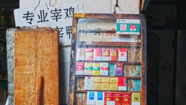 Vintage display of cigarette packs on an old wooden shelf, evoking a sense of nostalgia.