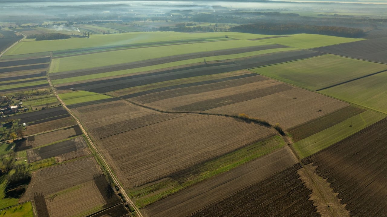 Expansive aerial shot of agricultural fields in Garešnica, Croatia, during daytime.