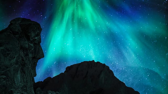 A breathtaking view of the Aurora Borealis illuminating a rock formation in Nordland, Norway.