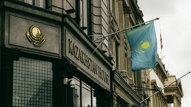 Kazakhstan House facade with flag and emblem in London, showcasing diplomacy and architecture.
