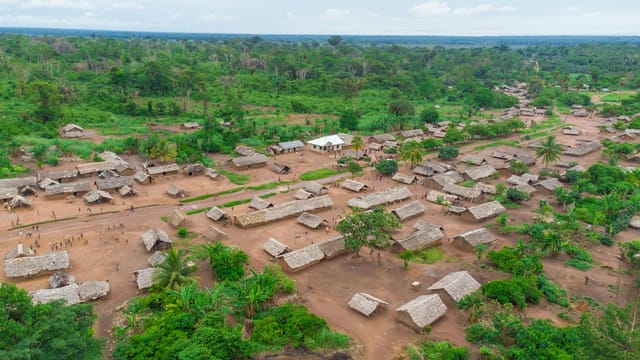 Aerial shot of a rural village surrounded by lush greenery in the Democratic Republic of the Congo.