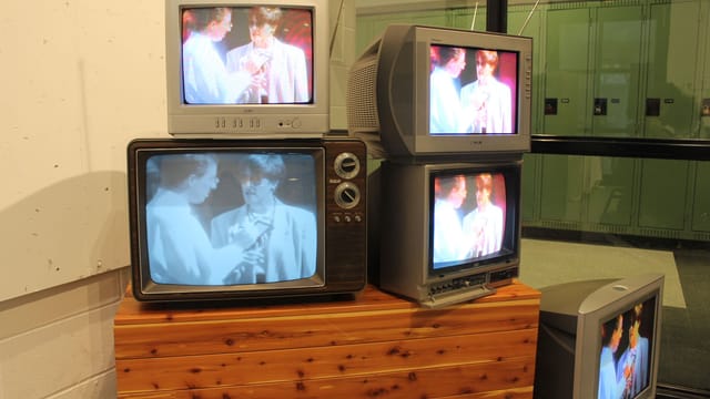 A collection of vintage CRT televisions showing retro media indoors, evoking nostalgia.