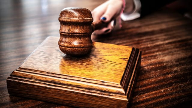A detailed shot of a wooden gavel on a judge's table, symbolizing justice.