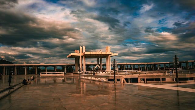 Scenic view of an architectural structure and plaza in Islamabad under dramatic evening skies.