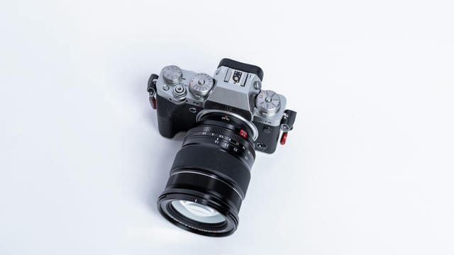 Overhead view of a DSLR camera with a large zoom lens on a white background.