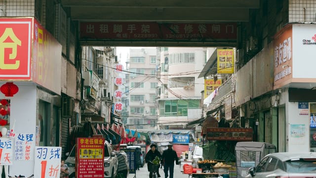 A busy street market in Sichuan Province, China, showcasing daily life with shops and vendors.