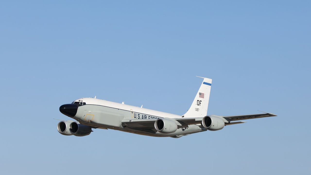 A U.S. Air Force jet flies high in a clear blue sky, showcasing powerful military aviation.