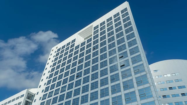 Impressive low-angle shot of modern skyscraper in The Hague, Netherlands against a clear blue sky.