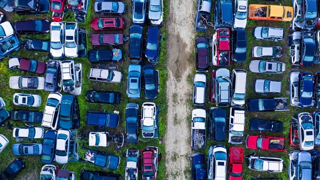 Aerial view of a car junkyard in Red Wing, MN, showcasing rows of parked vehicles.