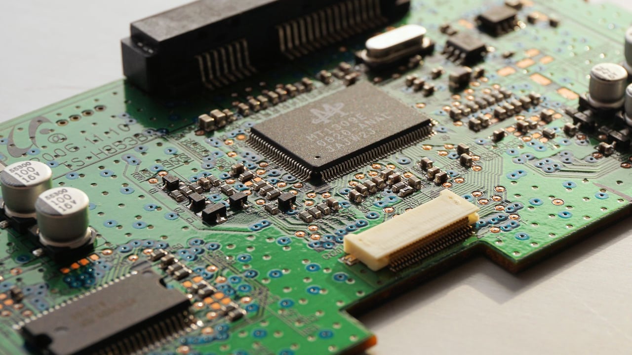 Detailed close-up photo of a circuit board highlighting microchip components and electronic circuits.