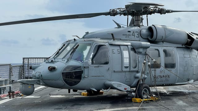 Close-up of Sikorsky SH-60 Seahawk helicopter secured on a naval ship deck.