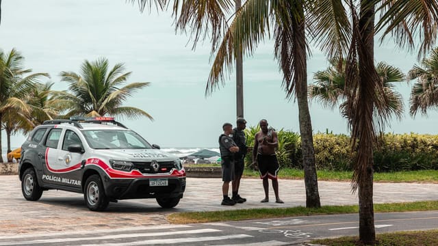 Police officers on duty near the beach with palm trees in Brazil.