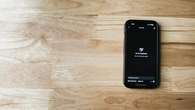Mobile phone displaying AI chatbot interface on a wooden table