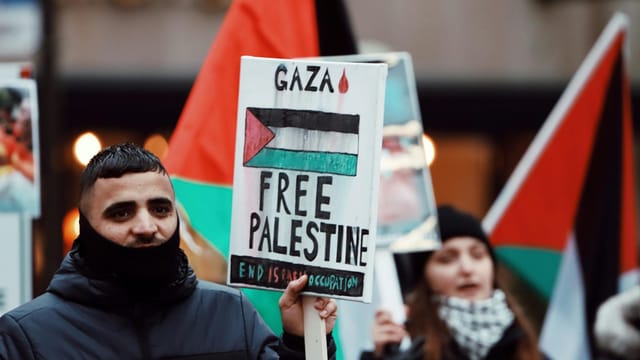Demonstrators hold signs and flags at a Free Palestine protest in Jönköping, Sweden.