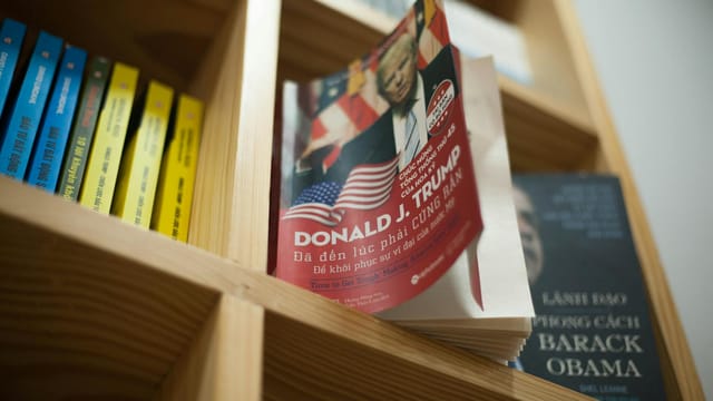 A close-up view of a bookshelf with books featuring political leaders in a bookstore setting.