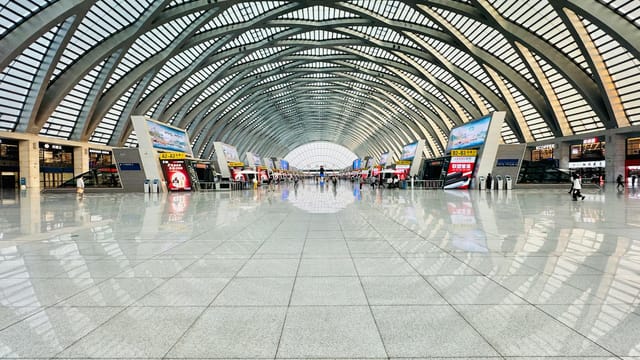 Panoramic view of a spacious and modern high-speed railway station interior with architectural elegance.