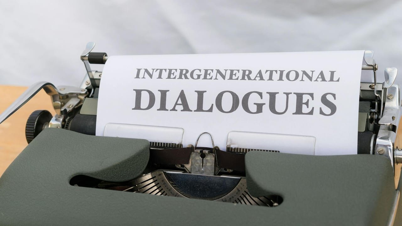 Close-up of a vintage typewriter with a sheet labeled 'Intergenerational Dialogues.'