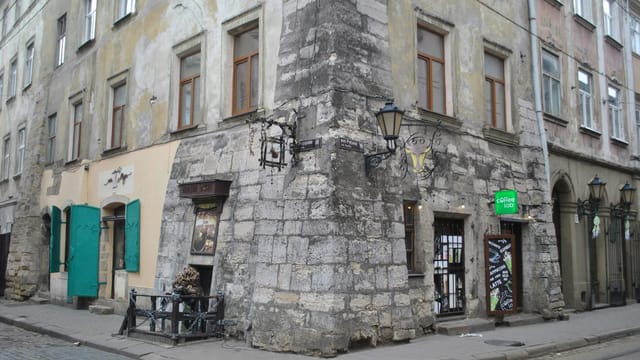 Old stone building with coffee shop in historic European city street.