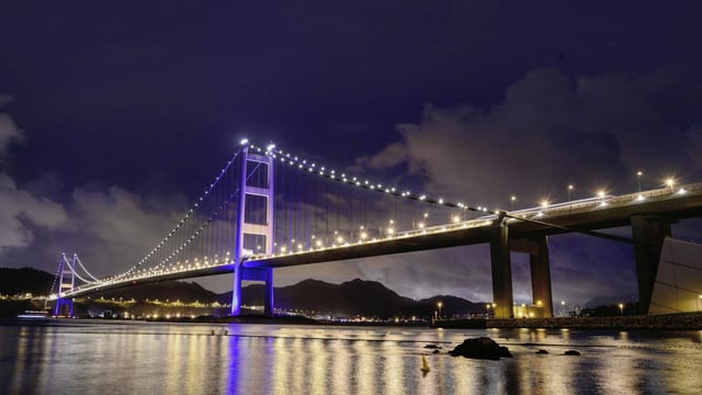 Scenic view of the illuminated Tsing Ma Bridge at night, showcasing iconic landmark in Hong Kong.