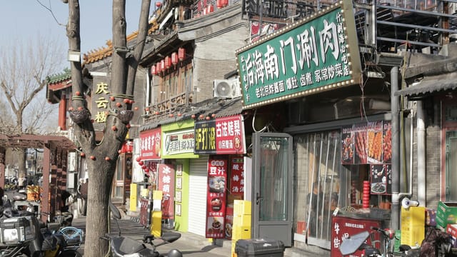 Capturing the vibrant street shops with Chinese signage in Beijing's local neighborhood.