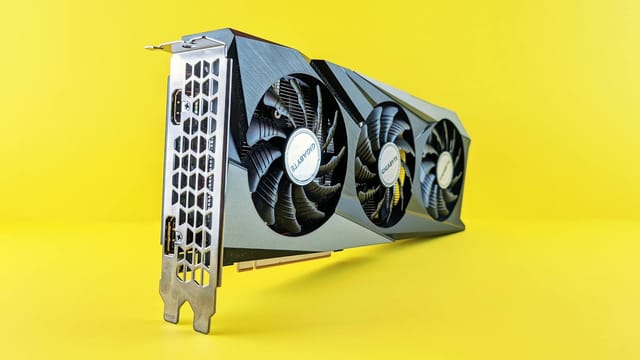 Close-up of a modern graphics card on a vibrant yellow background highlighting its design and technology.