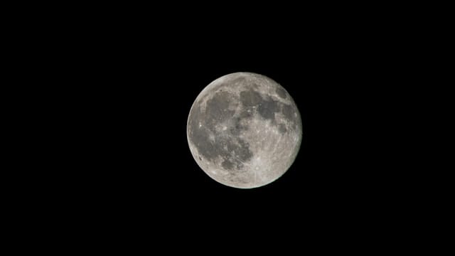 A high-resolution image of the full moon against a black night sky, showcasing lunar details.