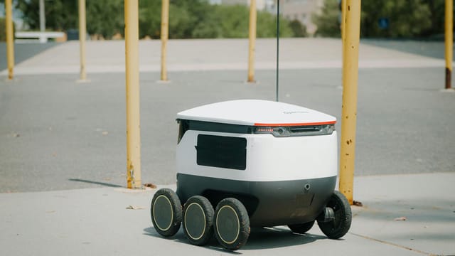 Futuristic autonomous delivery robot navigating a city street, showcasing modern technology.