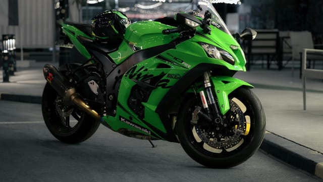 A sleek green motorcycle parked under urban night lights, showcasing modern design.