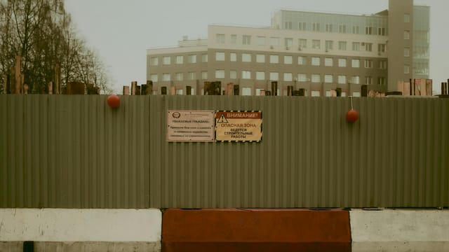 Photo of a fenced construction site with warning signs in Moscow.
