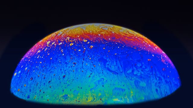 A colorful abstract sphere resembling a planet with swirling cosmic patterns and vibrant hues.