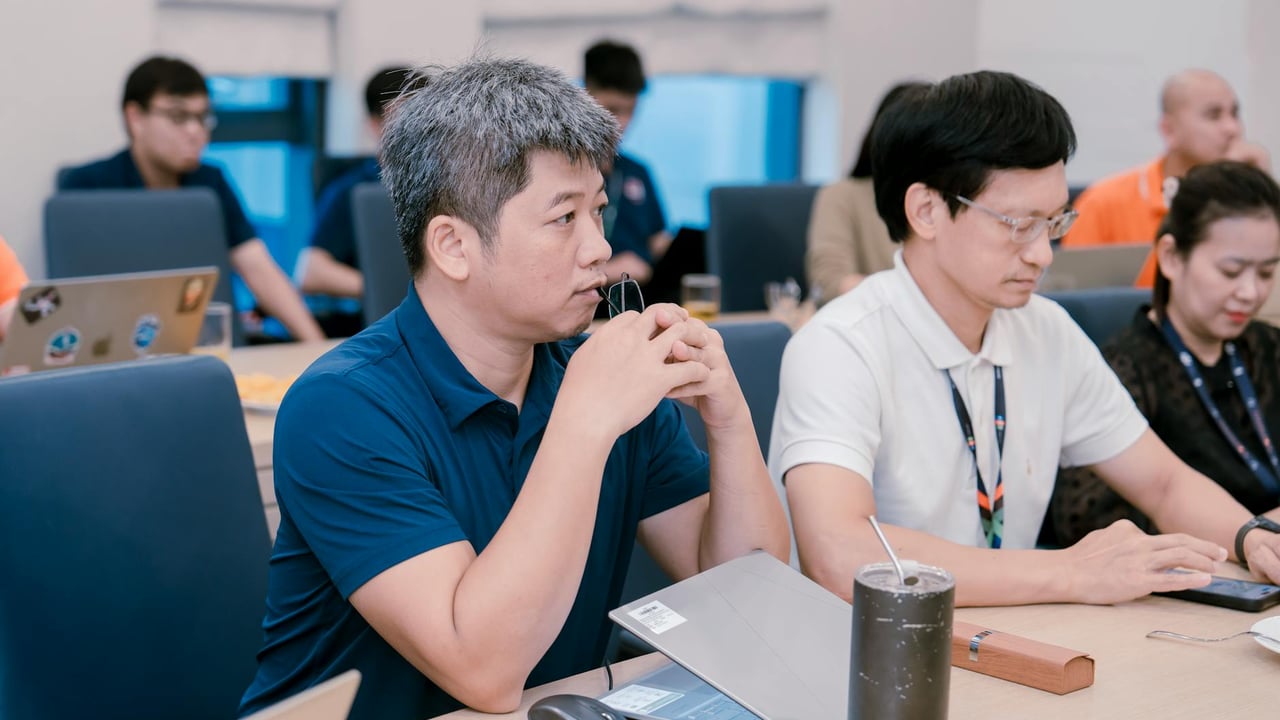 Engaged professionals in a corporate meeting room discussing ideas with laptops and notes.