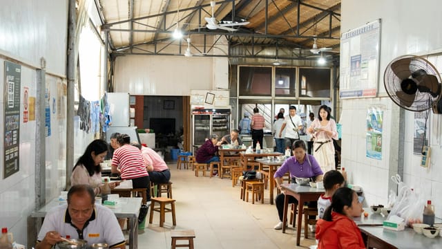 Customers enjoying a meal at a bustling eatery in Yunnan, China. Capturing local dining culture.