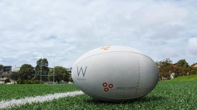 A detailed shot of a rugby ball on a green sports field, perfect for sports equipment themes.